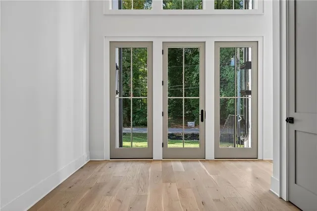 an empty room with floor to ceiling windows and plants