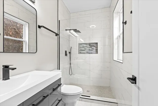 a bathroom with a sink a toilet and shower