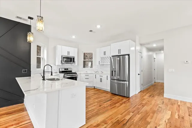 a kitchen with stainless steel appliances a refrigerator sink and cabinets