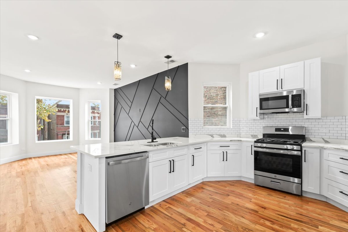 6128 South Rhodes Avenue, Unit 2 Chicago, IL 60637 - Photo 5 of 12 a kitchen with stainless steel appliances a stove sink and microwave