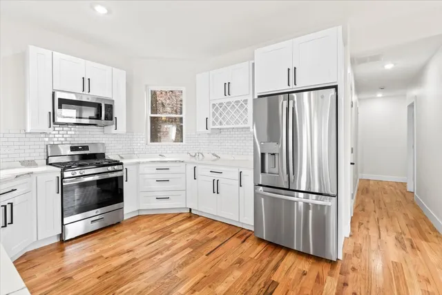 a kitchen with stainless steel appliances a refrigerator stove and microwave