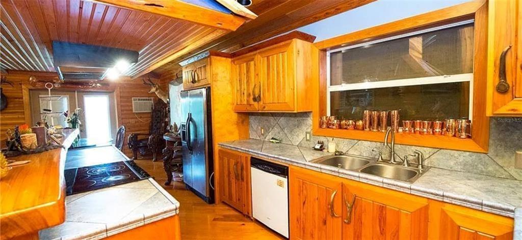 13255 Highway 441 Okeechobee, FL 34974 - Photo 11 of 29 a kitchen with stainless steel appliances granite countertop a sink and wooden cabinets