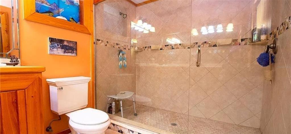 13255 Highway 441 Okeechobee, FL 34974 - Photo 21 of 29 a white toilet sitting next to a bathroom sink and a shower