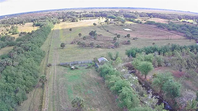 an aerial view of ocean and residential houses with outdoor space