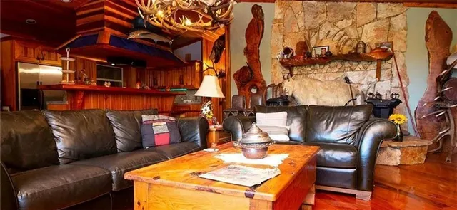 a view of a patio with couches table and chairs under an umbrella with a barbeque