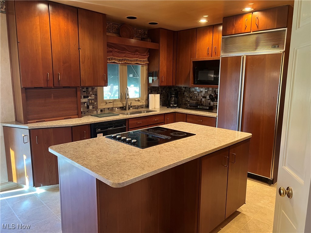 3330 Stanley Road Akron, OH 44333 - Photo 7 of 22 Kitchen with a center island, black appliances, sink, decorative backsplash, and light tile patterned floors
