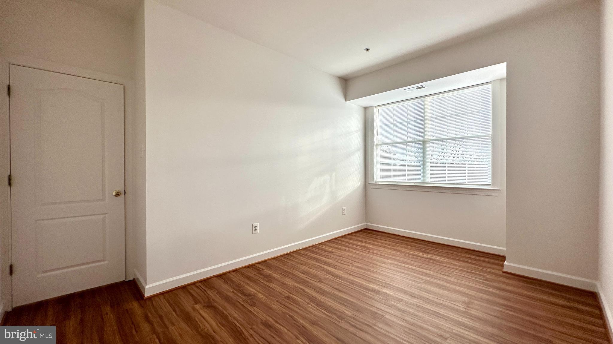 14020 Castle Ridge Way, Unit 38 Silver Spring, MD 20904 - Photo 19 of 30 a view of an empty room with wooden floor and a window
