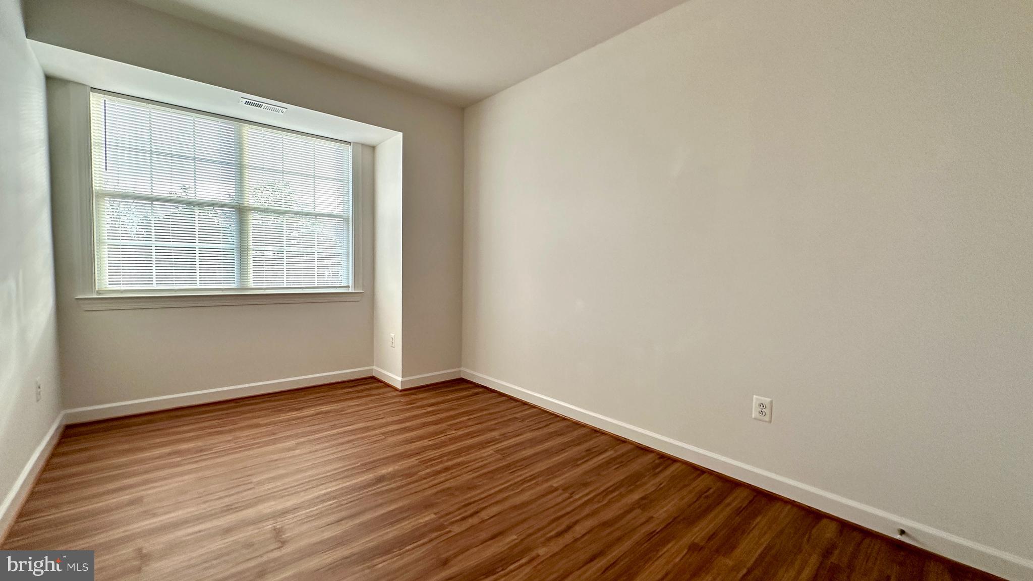 14020 Castle Ridge Way, Unit 38 Silver Spring, MD 20904 - Photo 22 of 30 an empty room with wooden floor and windows