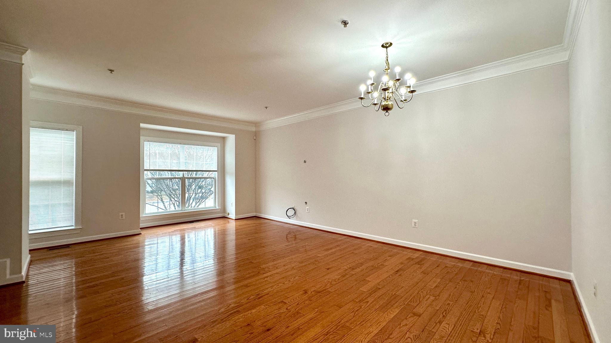 14020 Castle Ridge Way, Unit 38 Silver Spring, MD 20904 - Photo 6 of 30 an empty room with wooden floor chandelier fan and windows