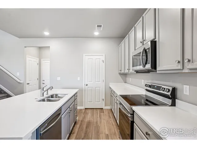 a kitchen that has a sink a stove and cabinets