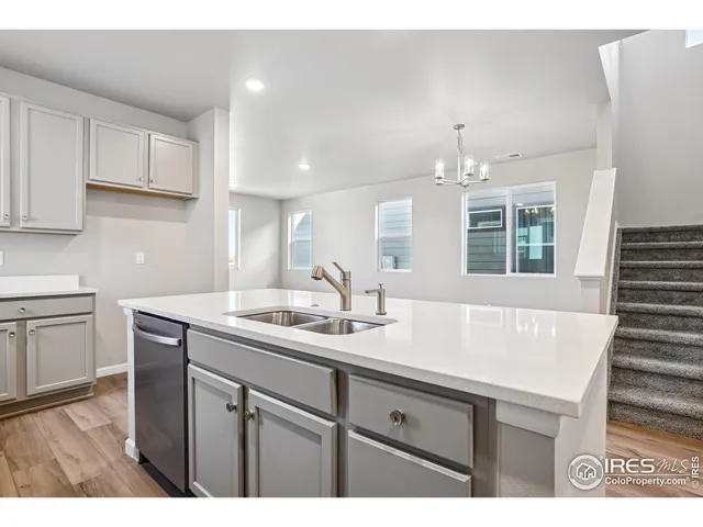 a kitchen with stainless steel appliances granite countertop a sink a stove a refrigerator and white cabinets
