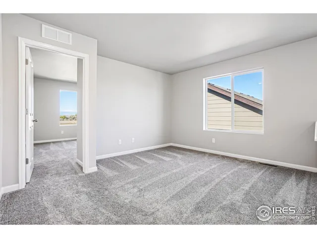 a view of an empty room with wooden floor and entryway