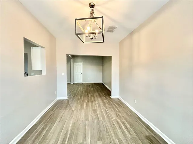 a view of a hallway with wooden floor and front door