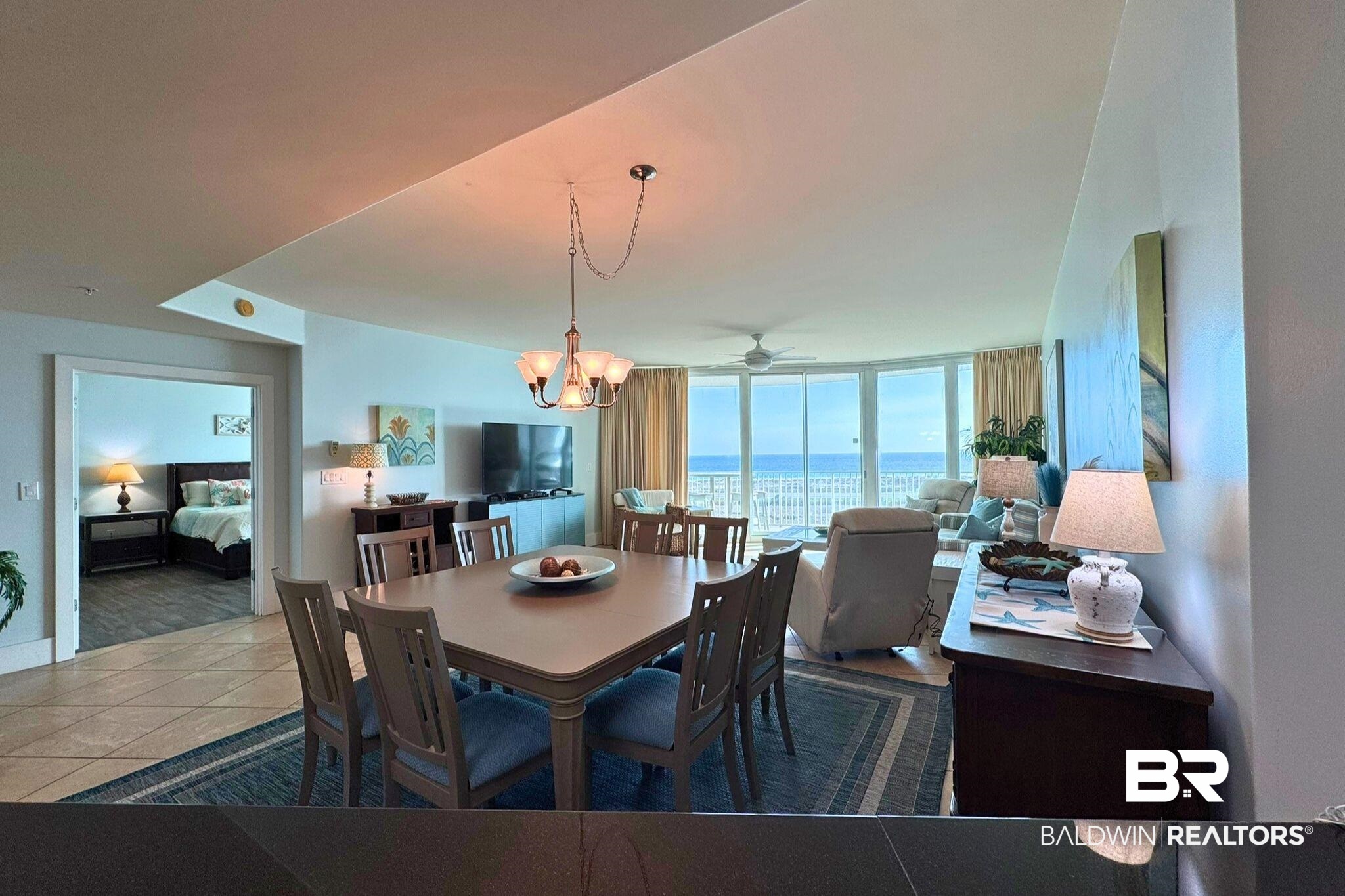28107 Perdido Beach Boulevard, Unit D714 Orange Beach, AL 36561 - Photo 18 of 88 Dining room featuring tile patterned flooring and ceiling fan with notable chandelier