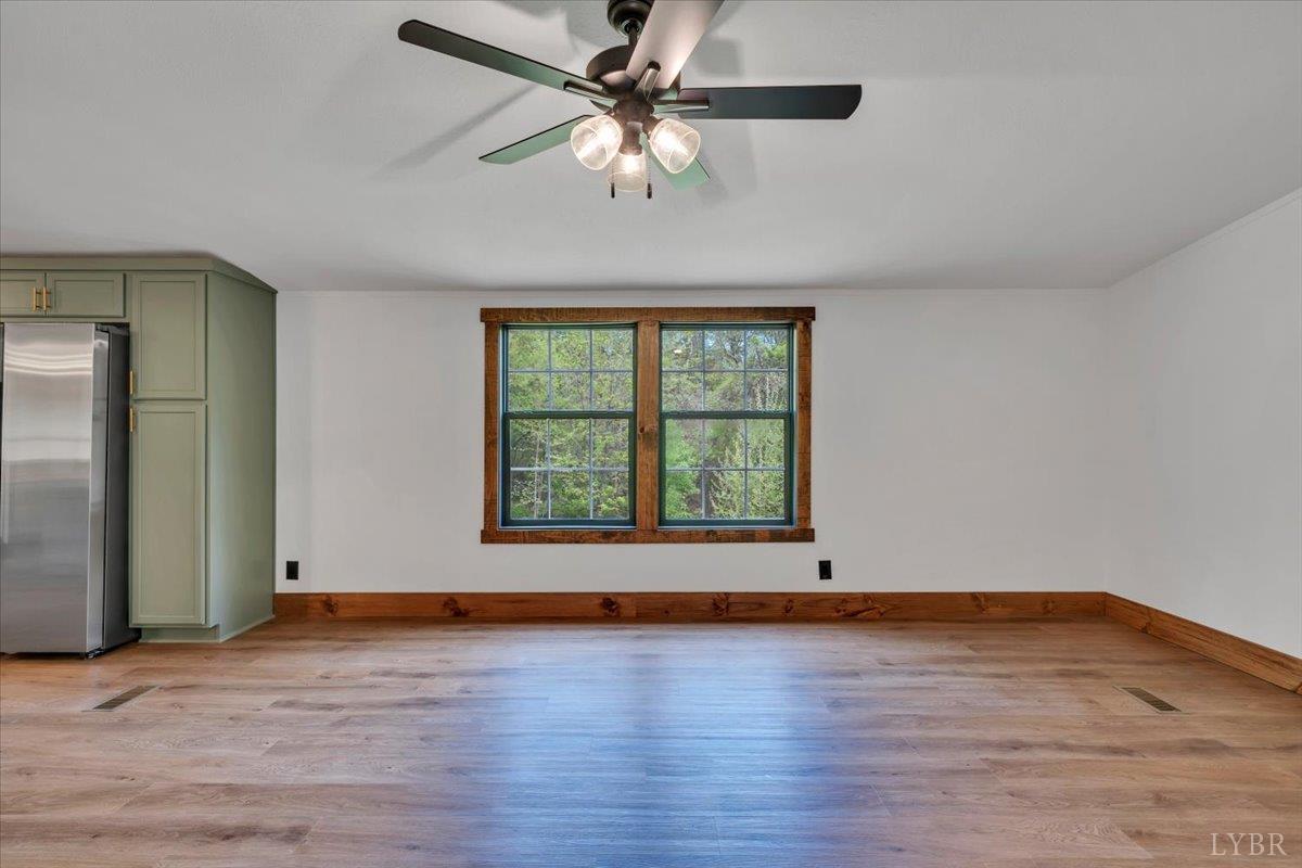 2781 Johnson School Road Thaxton, VA 24174 - Photo 20 of 63 an empty room with wooden floor chandelier fan and windows