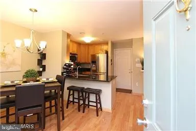 a kitchen with stainless steel appliances a table chairs refrigerator and sink