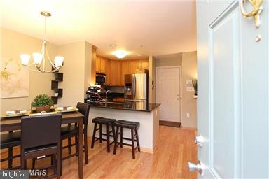 11864 Breton Court, Unit 14A Reston, VA 20191 - Photo 11 of 26 a kitchen with stainless steel appliances a table chairs refrigerator and sink