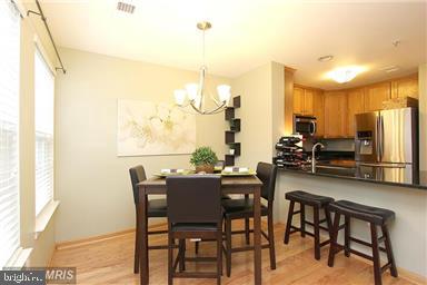 11864 Breton Court, Unit 14A Reston, VA 20191 - Photo 13 of 26 a view of a dining room with furniture a chandelier and wooden floor