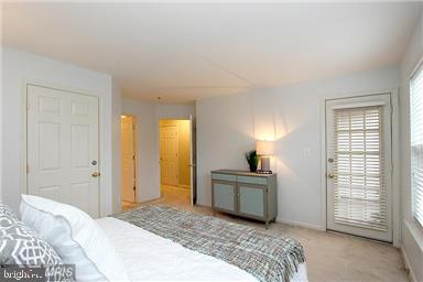 11864 Breton Court, Unit 14A Reston, VA 20191 - Photo 17 of 26 a bedroom with a bed and a chandelier