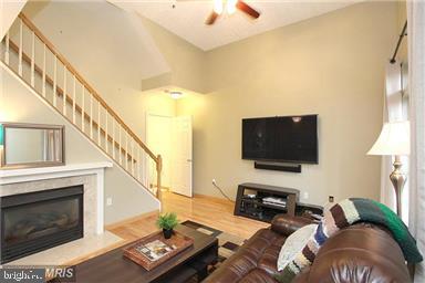 11864 Breton Court, Unit 14A Reston, VA 20191 - Photo 4 of 26 a living room with furniture a fireplace and a flat screen tv