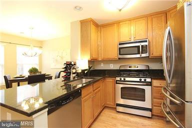 11864 Breton Court, Unit 14A Reston, VA 20191 - Photo 10 of 26 a kitchen with a stove a sink and a microwave