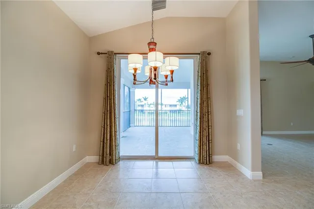 en empty room with sliding glass door and chandelier