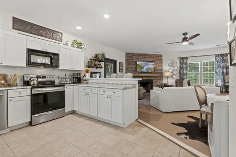 a kitchen with furniture a flat screen tv and a window