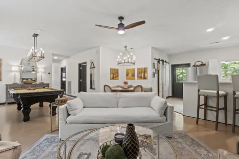 a living room with furniture a fireplace and a chandelier