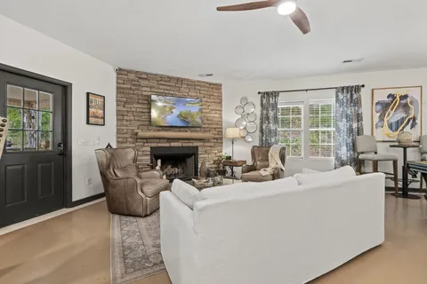 a living room with furniture a fireplace and a flat screen tv