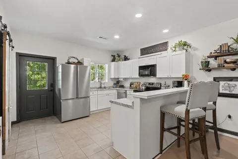 a kitchen with stainless steel appliances a refrigerator stove microwave and white cabinets