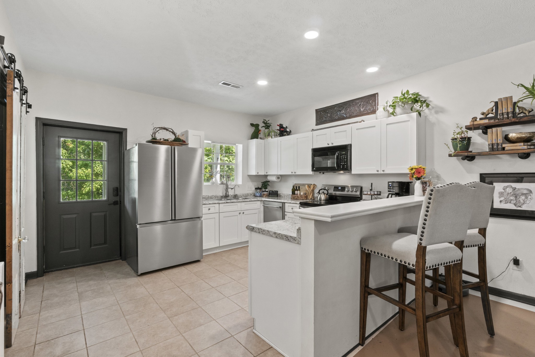 3336 Green Grove Road Hartsville, TN 37074 - Photo 10 of 64 a kitchen with stainless steel appliances a refrigerator stove microwave and white cabinets