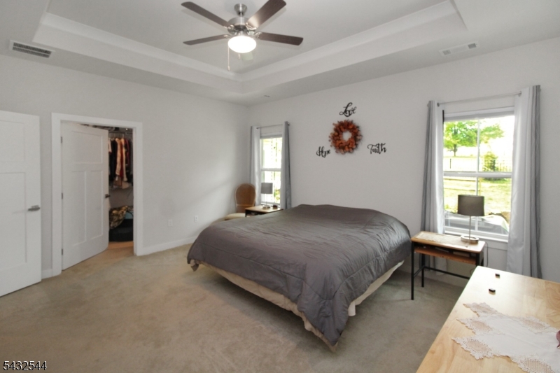 21 Harris Hawk Road Washington, NJ 07882 - Photo 13 of 26 a bedroom with a bed and a chandelier