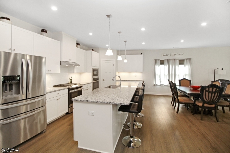 21 Harris Hawk Road Washington, NJ 07882 - Photo 7 of 26 a kitchen with appliances wooden floor and a dining table