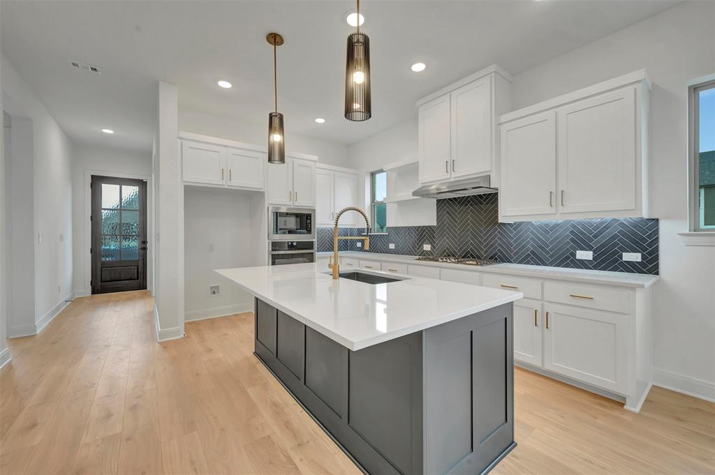 1856 Lightner Road Van Alstyne, TX 75495 - Photo 13 of 33 Contemporary kitchen featuring a large central island with a white countertop and dark base cabinetry