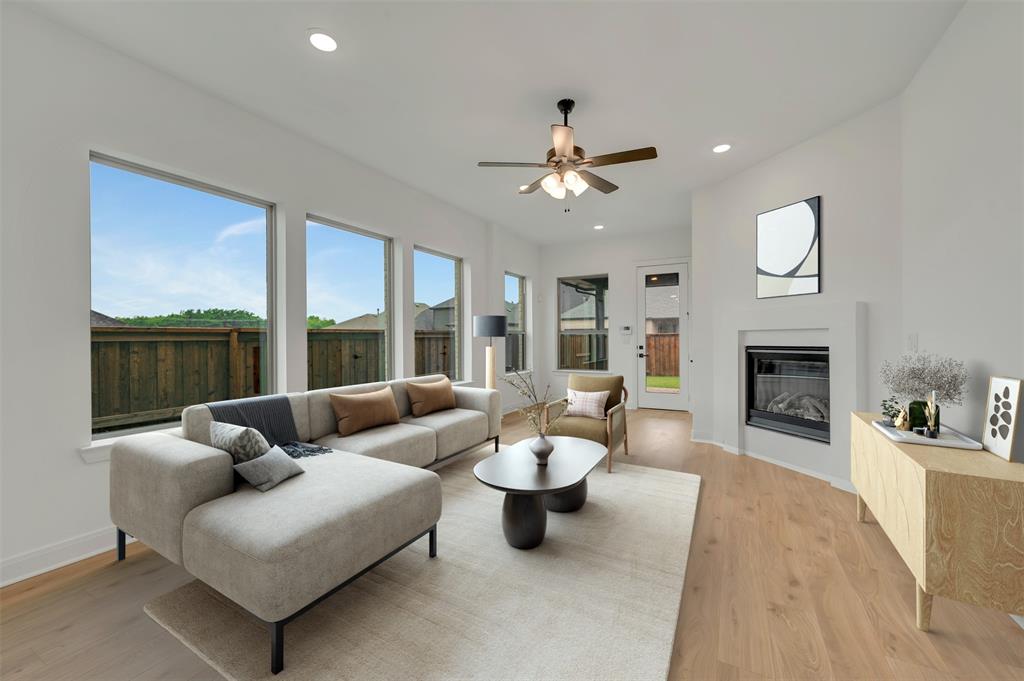 1856 Lightner Road Van Alstyne, TX 75495 - Photo 24 of 33 Spacious living area featuring light wood-finish flooring, a contemporary fireplace, and a ceiling fan