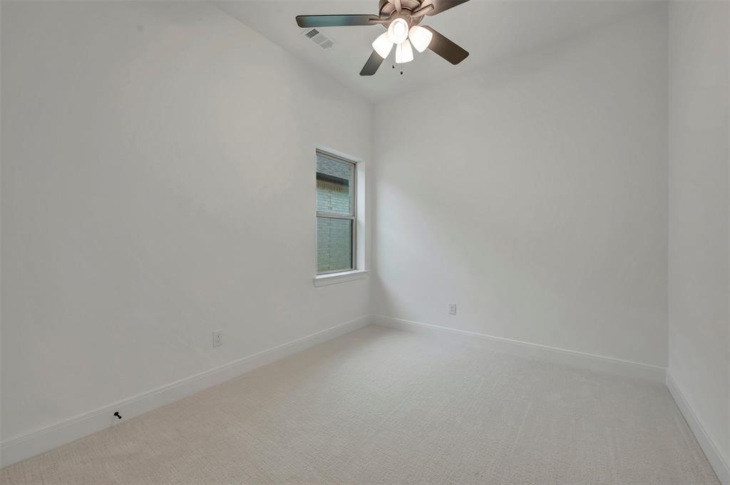 1856 Lightner Road Van Alstyne, TX 75495 - Photo 30 of 33 Neutral carpeted room featuring a ceiling fan with integrated lighting, a window with white trim, white baseboards, and light-toned walls