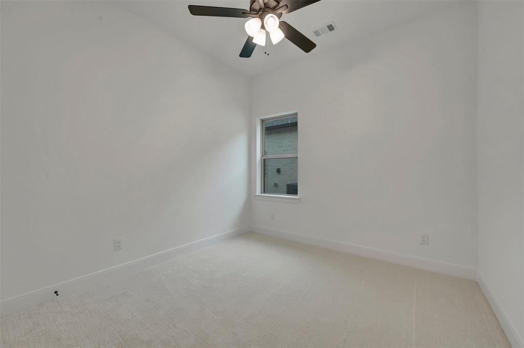1856 Lightner Road Van Alstyne, TX 75495 - Photo 32 of 33 Neutral-toned carpeting paired with white walls, a single window, and a ceiling fan with integrated lighting