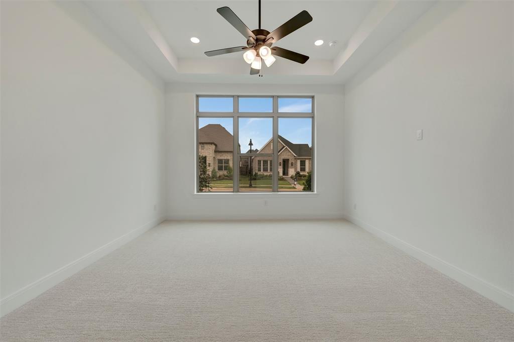 1856 Lightner Road Van Alstyne, TX 75495 - Photo 6 of 33 Spacious room featuring a tray ceiling with recessed lighting, a modern ceiling fan, large windows, plush carpeting, and crisp white baseboards