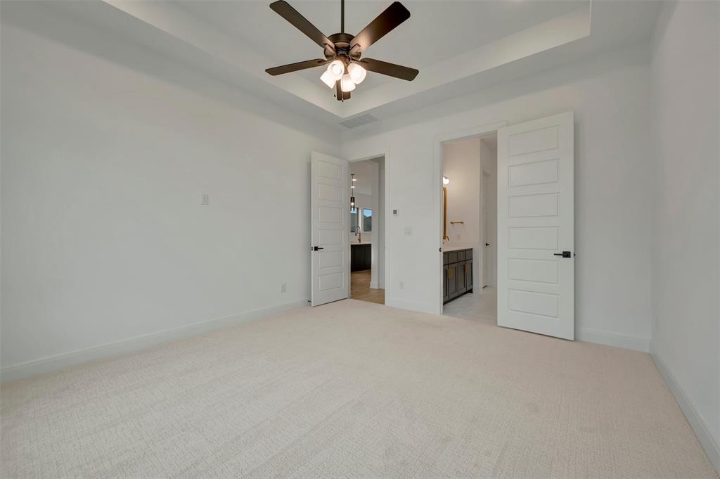 1856 Lightner Road Van Alstyne, TX 75495 - Photo 8 of 33 Spacious room featuring light-colored carpeting and a tray ceiling with a dark-toned ceiling fan