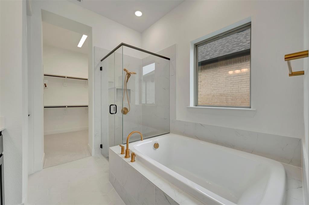 1856 Lightner Road Van Alstyne, TX 75495 - Photo 9 of 33 Bathroom featuring a freestanding soaking tub with brass fixtures, a glass-enclosed shower with black trim, and a window