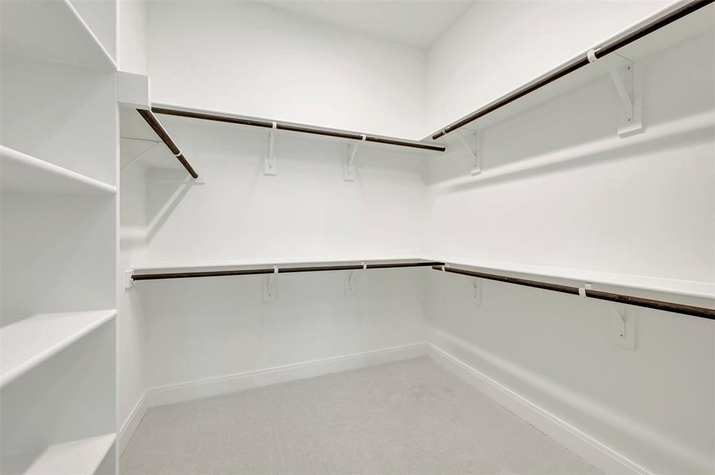 1856 Lightner Road Van Alstyne, TX 75495 - Photo 10 of 33 Walk-in closet featuring built-in shelving, white walls, light gray carpet, and multiple clothing rods