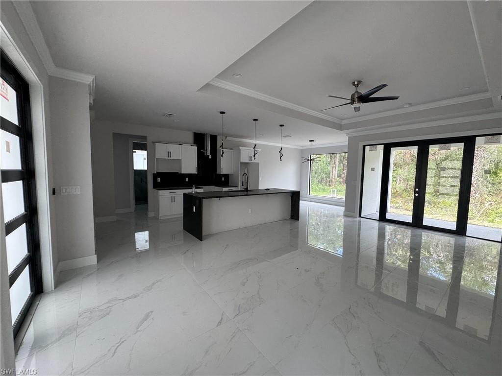 4263 18th Avenue Southeast Naples, FL 34117 - Photo 5 of 23 a large kitchen with stainless steel appliances kitchen island granite countertop a refrigerator and a stove top oven