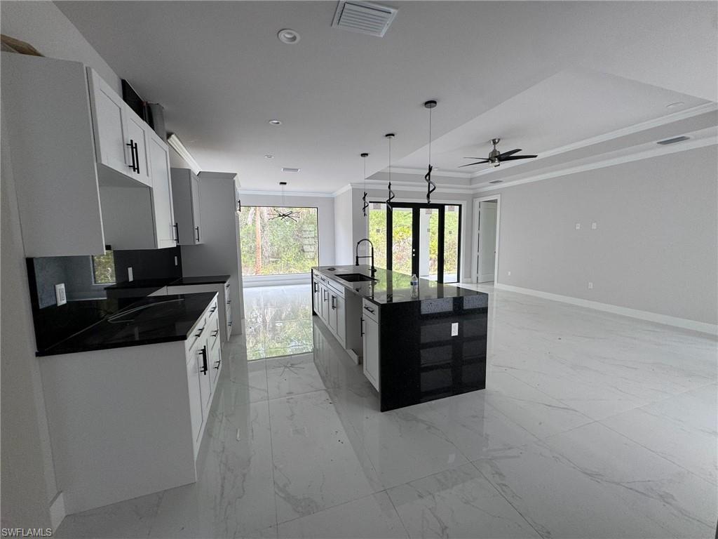 4263 18th Avenue Southeast Naples, FL 34117 - Photo 7 of 23 a large kitchen with granite countertop a sink and cabinets