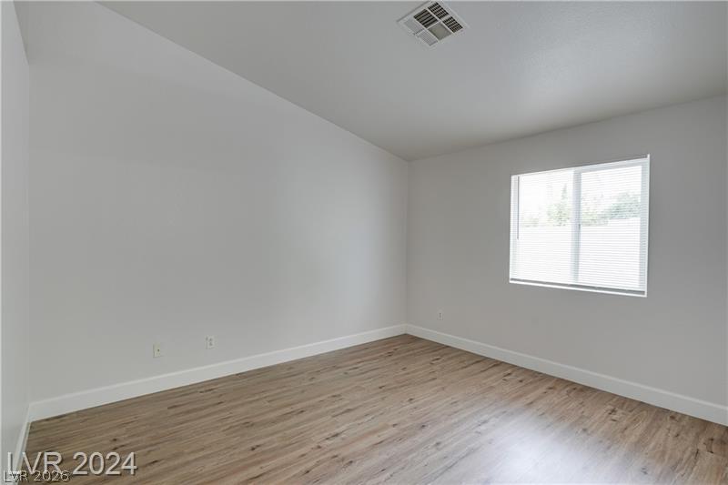 9660 Crystal Ridge Road Las Vegas, NV 89123 - Photo 12 of 18 A well-lit bedroom features durable laminate flooring and a large window, offering a pleasant living space.
