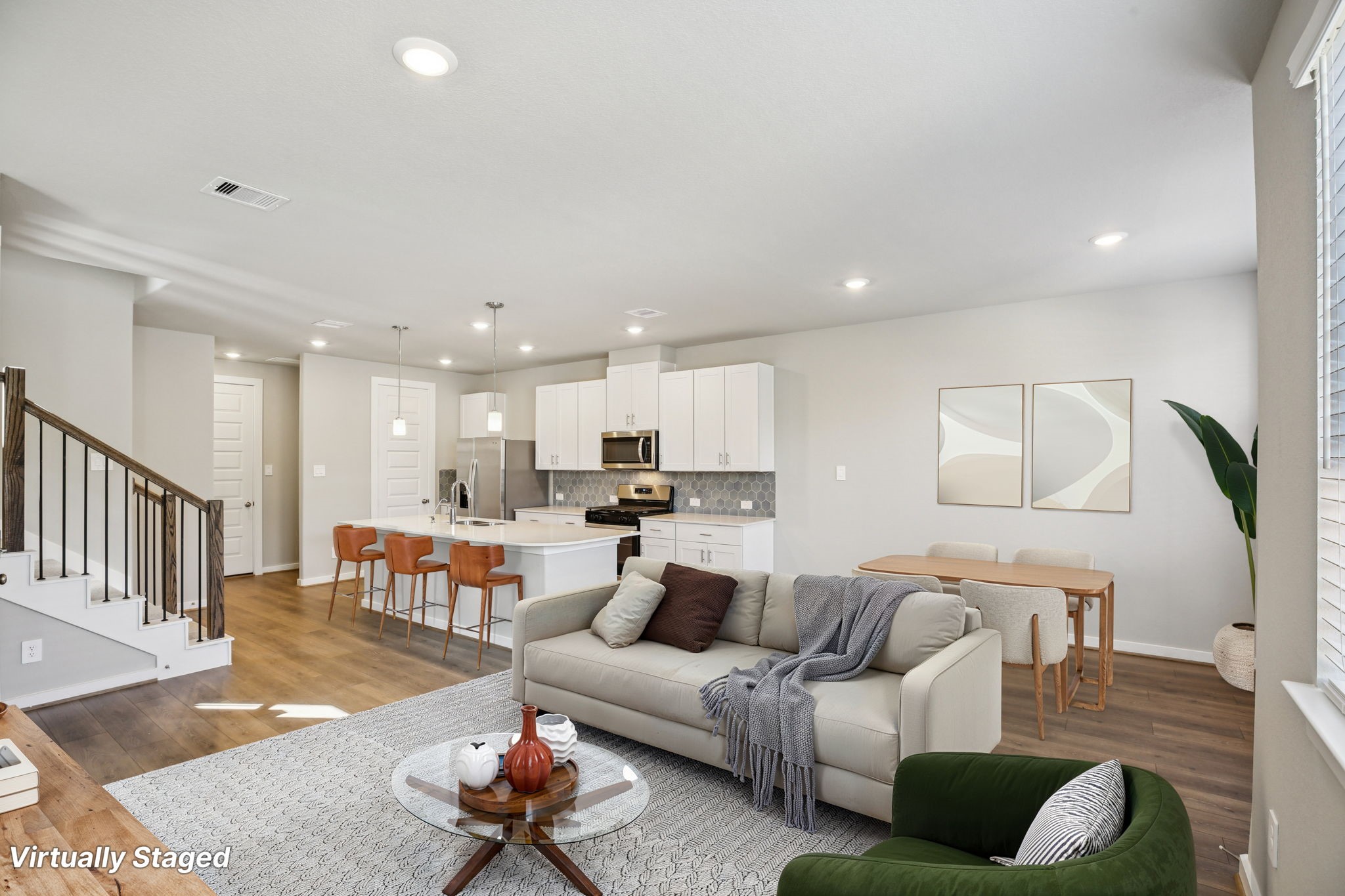 a living room with furniture and a dining table with wooden floor