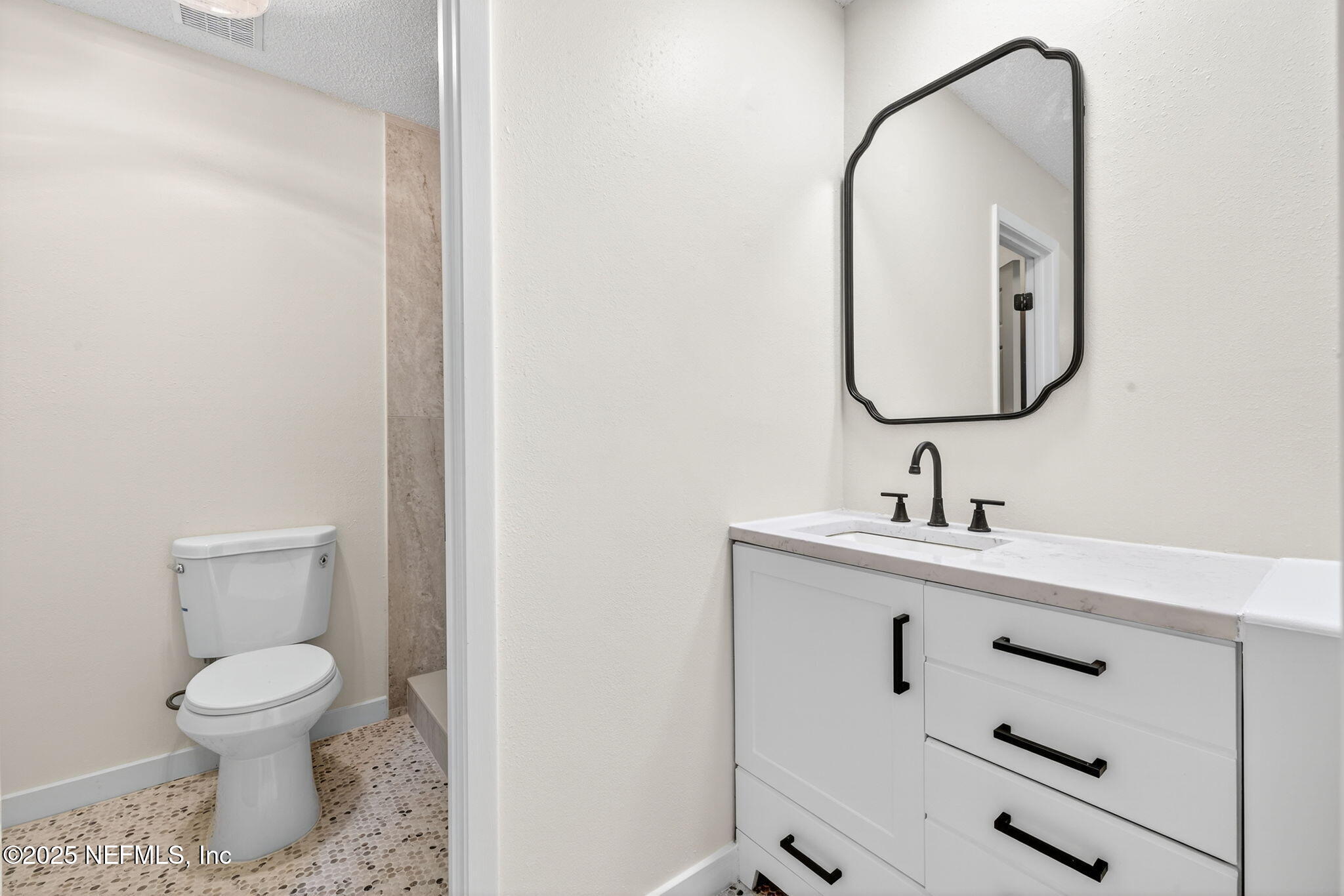 258 Wisteria Road St. Augustine, FL 32086 - Photo 19 of 33 a bathroom with a toilet sink and mirror