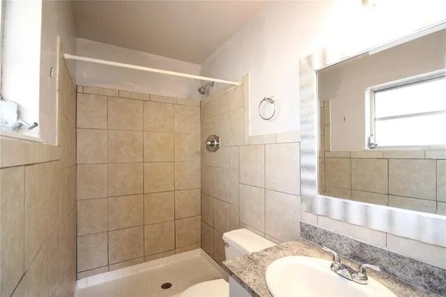 a bathroom with a sink a toilet and shower