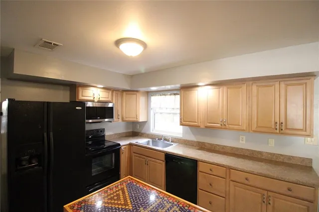 a kitchen with granite countertop a refrigerator and a sink