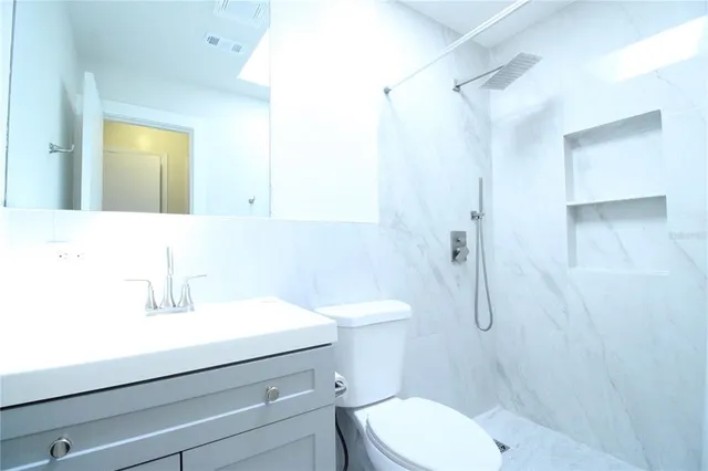a bathroom with a sink a toilet and shower