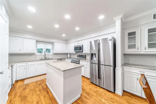 a kitchen with a refrigerator a sink and a stove top oven